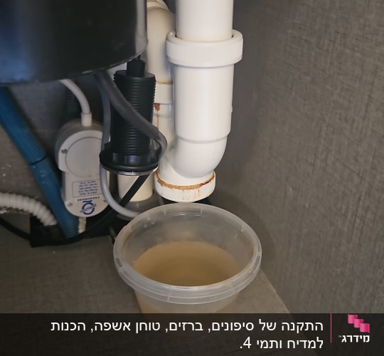 צינור ביוב מתחת לכיור עם דליפת מים לתוך קערה